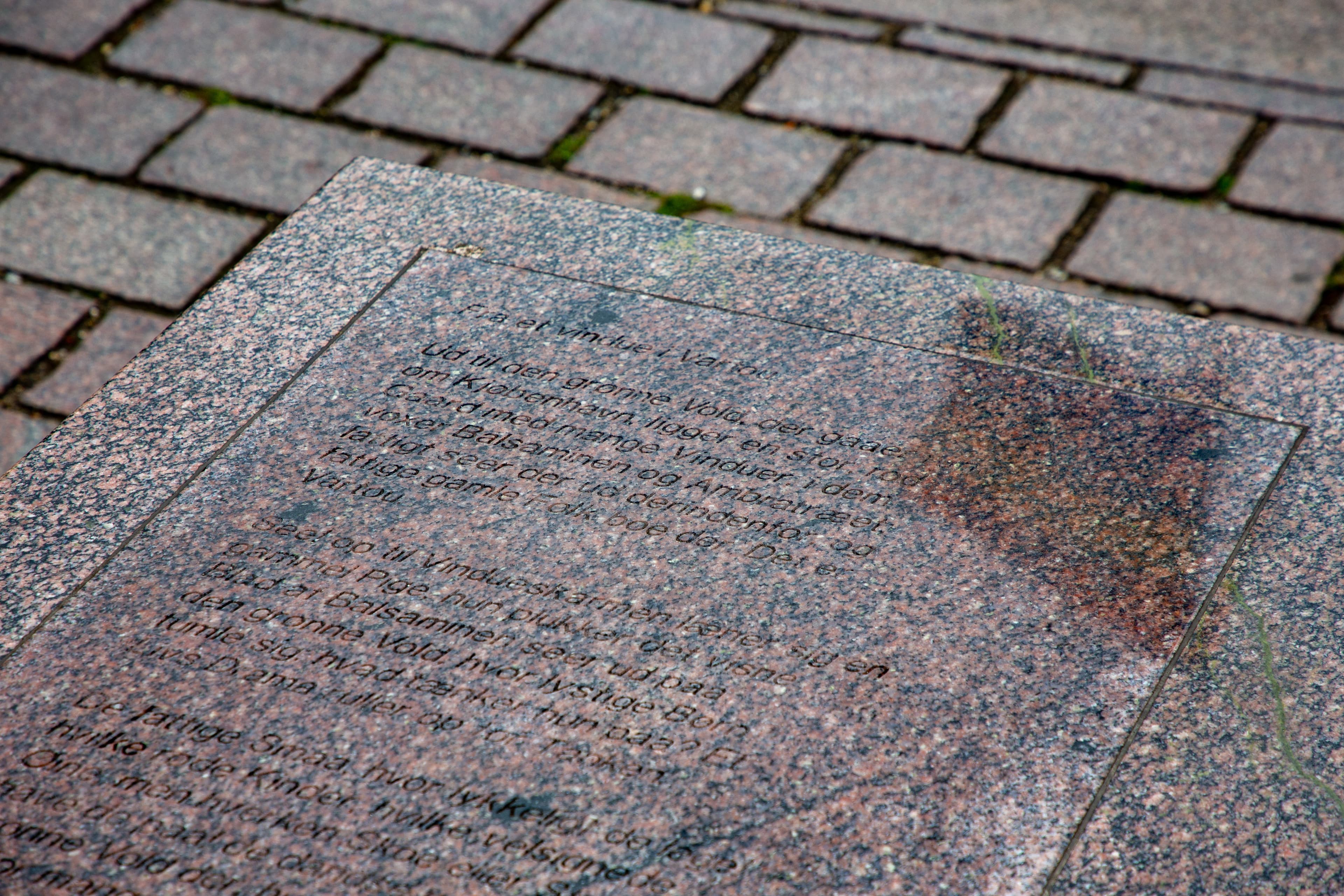 Regnbuepladsen sten med tekst