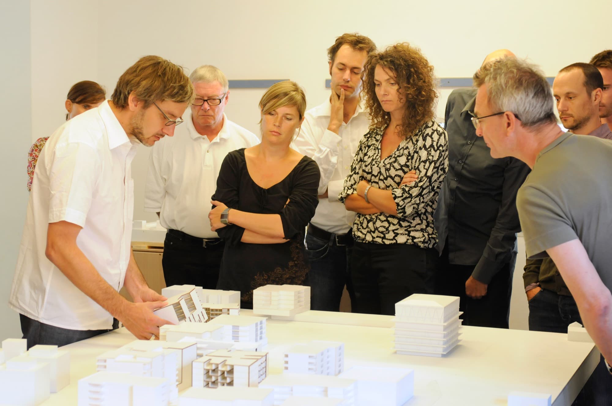 Community dialogue was integral to the development of Mehr Als Wohnen. Here, future residents and community members gather around a site model, which shows Christian Kerez’ Leutschenbach School in one corner.